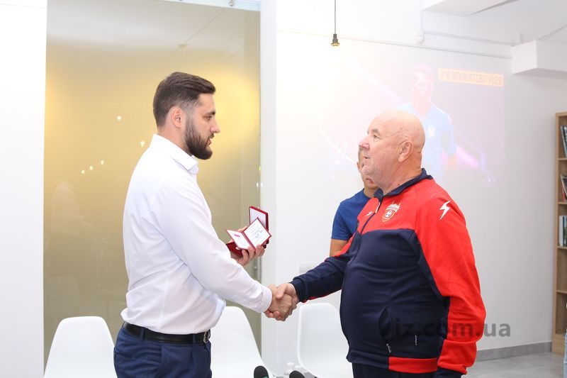 Анатолий Пустоваров вручает тренеру награду