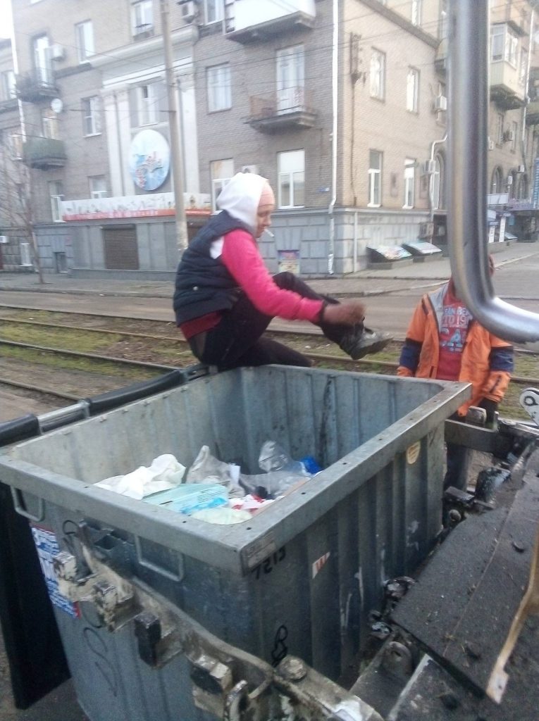 В Запорожье женщина не хотела вылезать из мусорного контейнера - фото